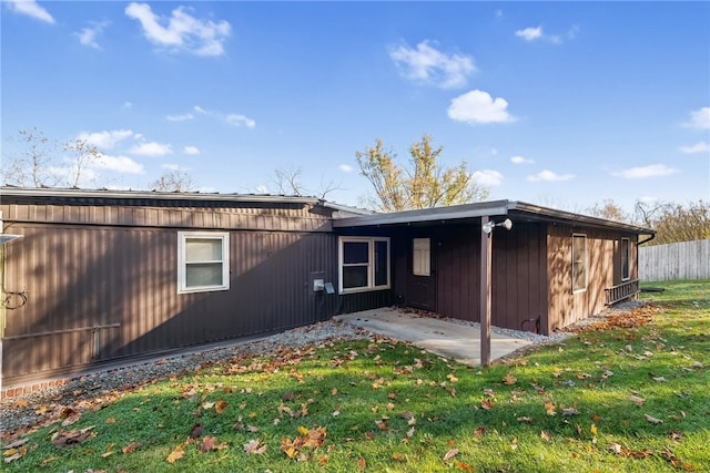 rear view of house featuring a patio area and a lawn