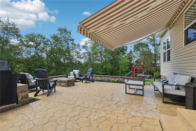 view of patio featuring a playground and an outdoor living space with a fire pit