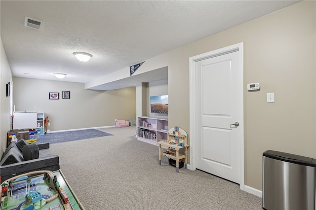 recreation room featuring carpet floors and a textured ceiling