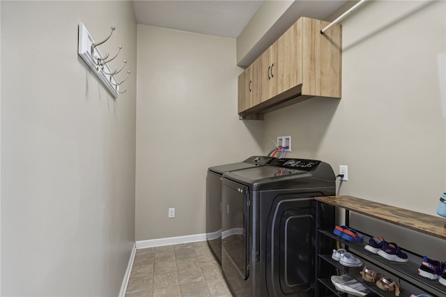 clothes washing area with washer and dryer and cabinets