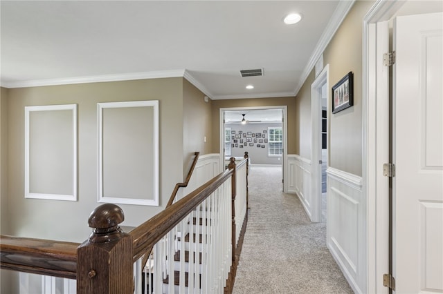 corridor featuring crown molding and light colored carpet