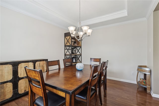 dining space with ornamental molding, a notable chandelier, dark hardwood / wood-style floors, and a tray ceiling