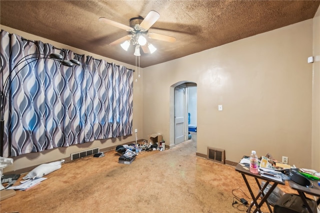 interior space with ceiling fan and a textured ceiling