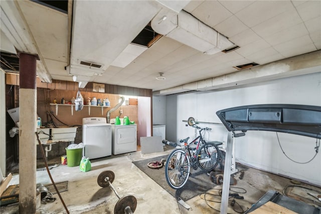 basement featuring wood walls and separate washer and dryer