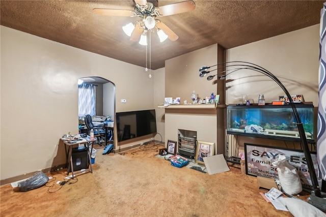 carpeted living room with a textured ceiling and ceiling fan