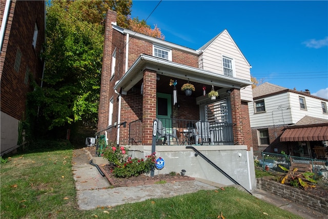 view of front facade featuring covered porch, a front yard, and central AC unit