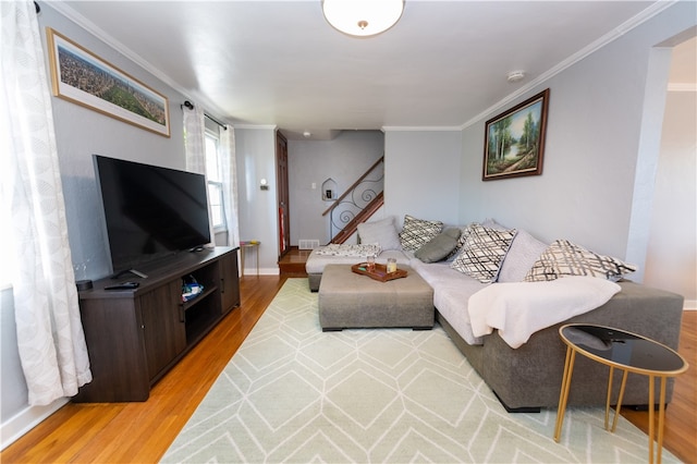 living room with crown molding and light wood-type flooring