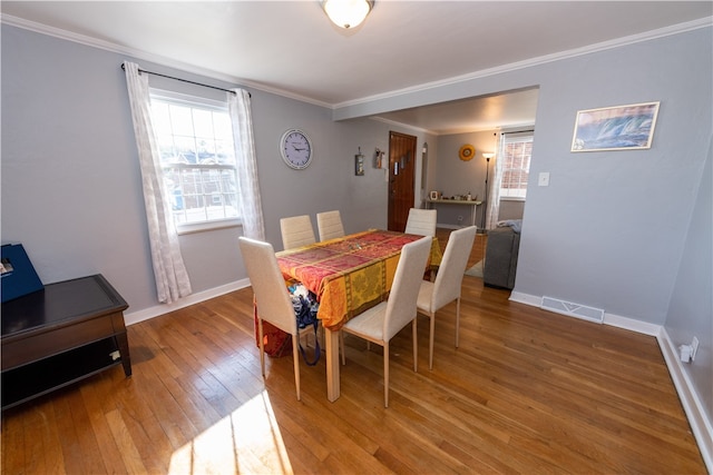 dining room featuring crown molding and hardwood / wood-style flooring