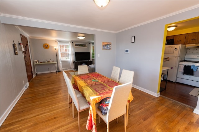 dining space featuring hardwood / wood-style floors and crown molding