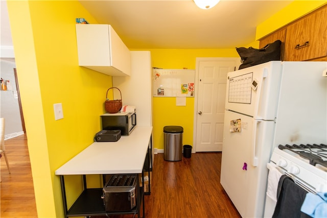 kitchen with appliances with stainless steel finishes and dark hardwood / wood-style floors