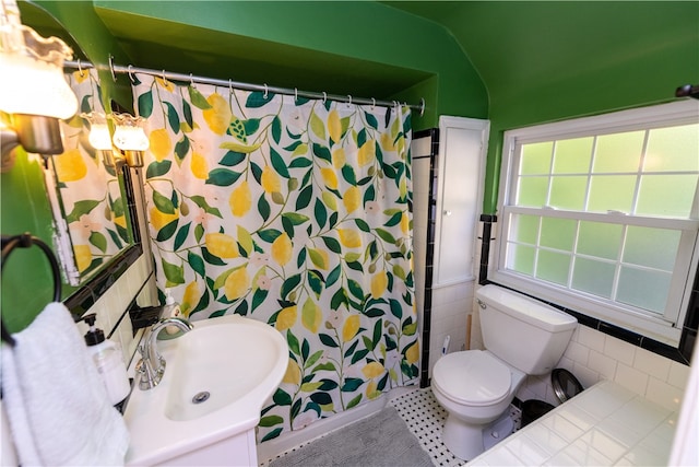 bathroom with a shower with shower curtain, toilet, vaulted ceiling, vanity, and tile patterned flooring