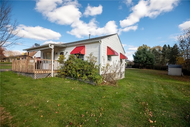 view of home's exterior featuring a storage shed, a yard, and a deck