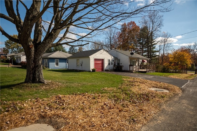 exterior space featuring a garage, an outdoor structure, and a lawn