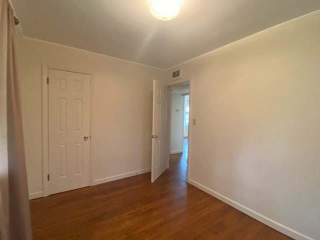 spare room featuring crown molding and dark hardwood / wood-style floors