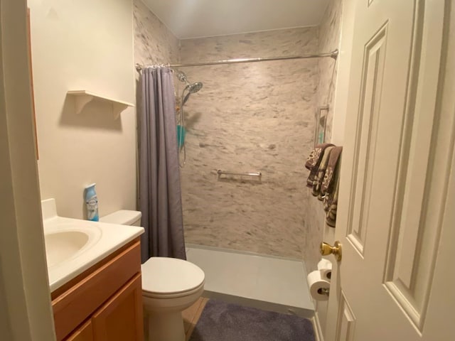 bathroom featuring toilet, vanity, and walk in shower