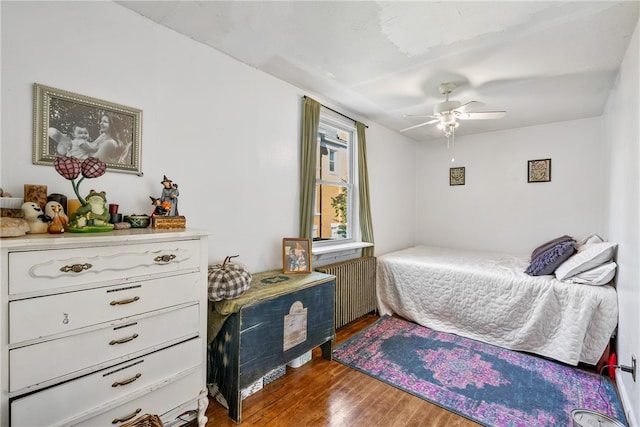 bedroom with ceiling fan, hardwood / wood-style flooring, and radiator heating unit