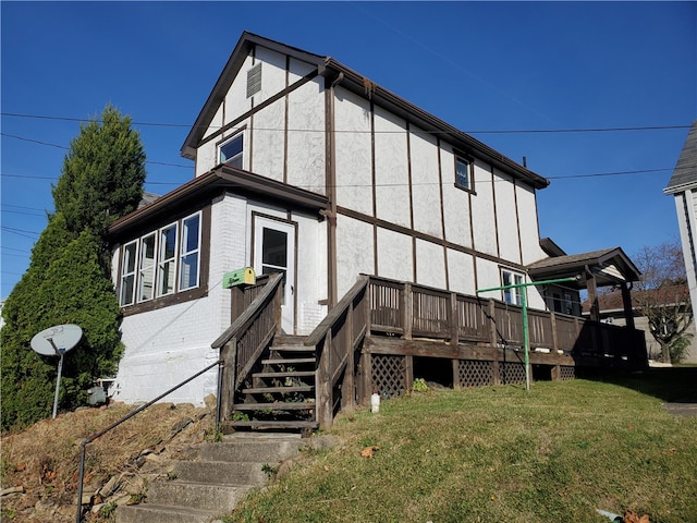 rear view of house with a deck and a lawn