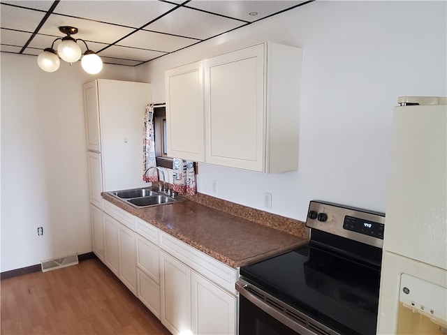 kitchen featuring white cabinetry, stainless steel range with electric stovetop, and sink