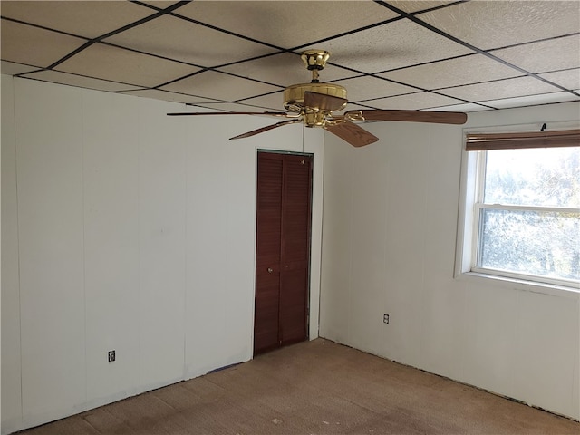 unfurnished room with ceiling fan, a paneled ceiling, and light colored carpet