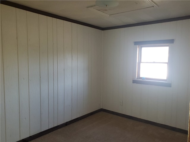 empty room with dark carpet, ornamental molding, and wooden walls