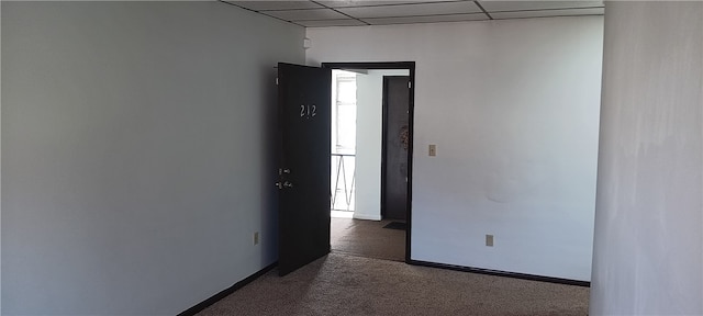 carpeted spare room with a drop ceiling