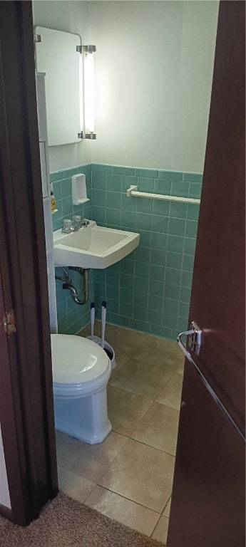 bathroom with tile patterned flooring, sink, tile walls, and toilet