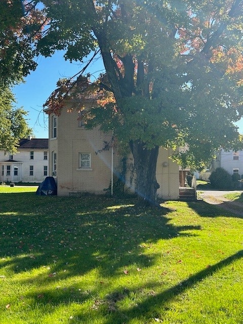 view of side of home with a lawn