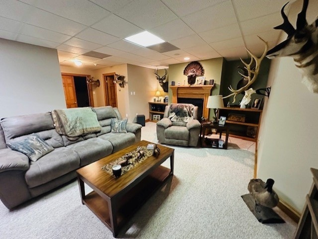 carpeted living room featuring a drop ceiling