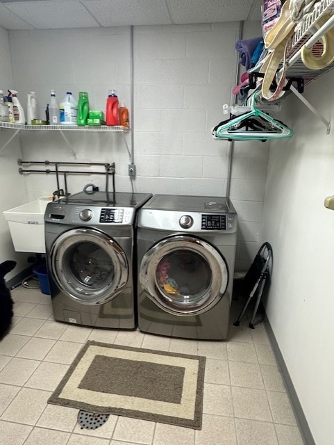 clothes washing area with separate washer and dryer and sink