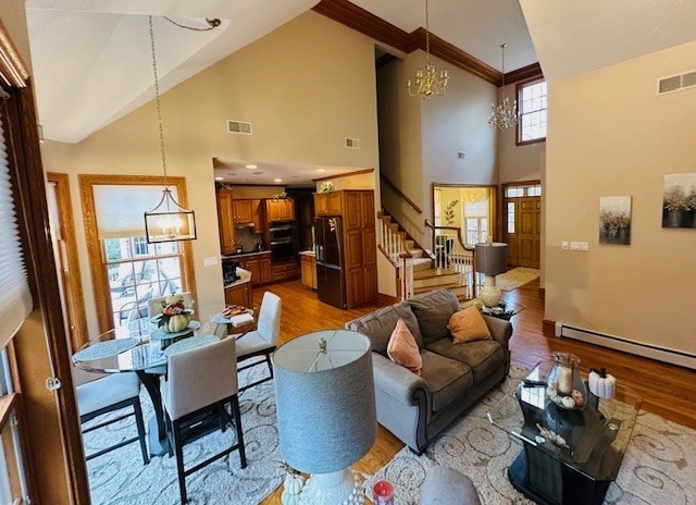 living room featuring light wood-type flooring, high vaulted ceiling, and a chandelier