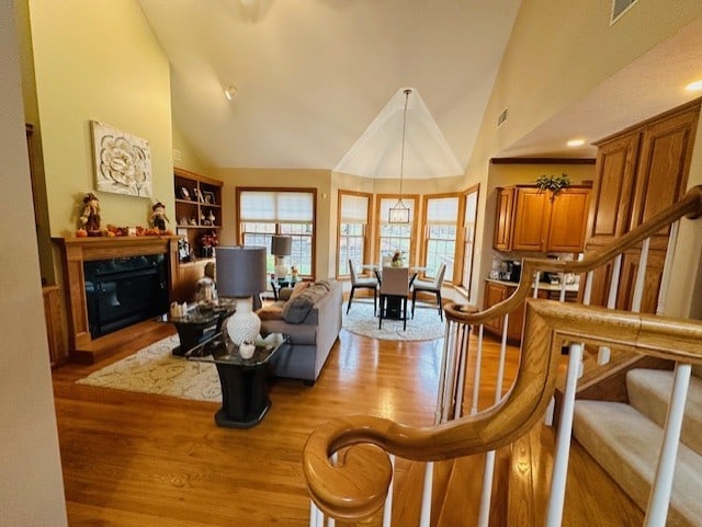 living room featuring light hardwood / wood-style floors and high vaulted ceiling