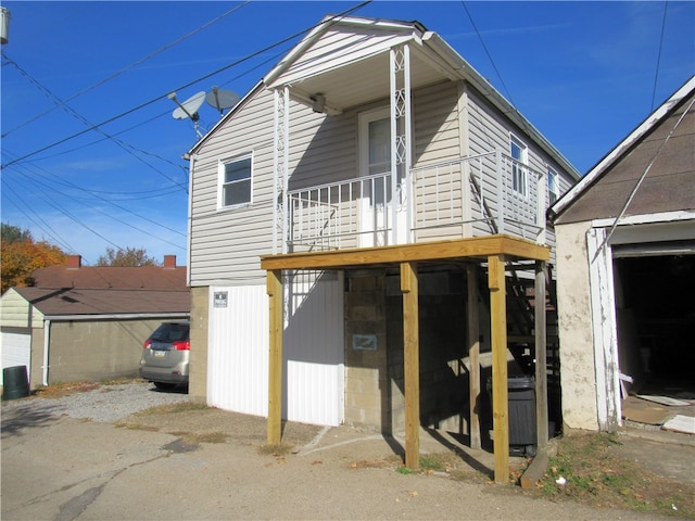 back of house featuring an outdoor structure and a garage