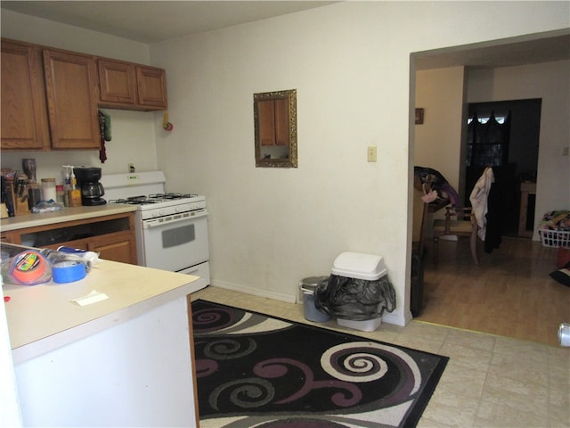 kitchen featuring white range with gas stovetop and light hardwood / wood-style floors