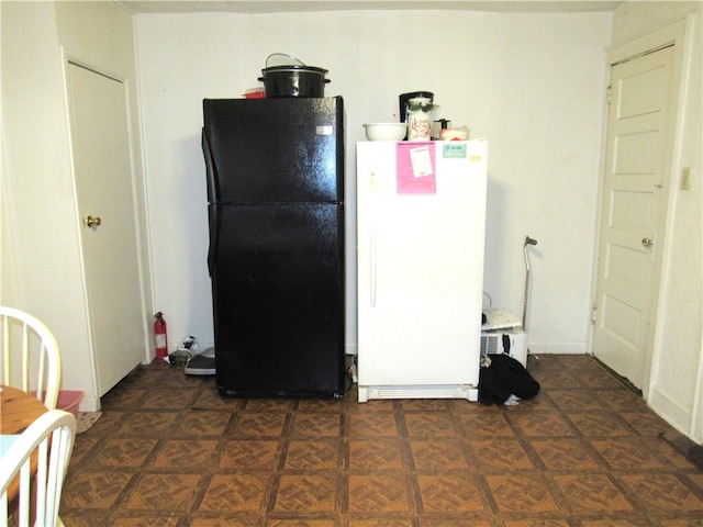 kitchen with dark parquet floors, white fridge, and black refrigerator