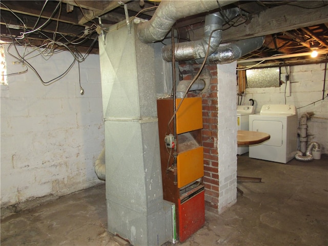 basement featuring heating unit and washing machine and clothes dryer