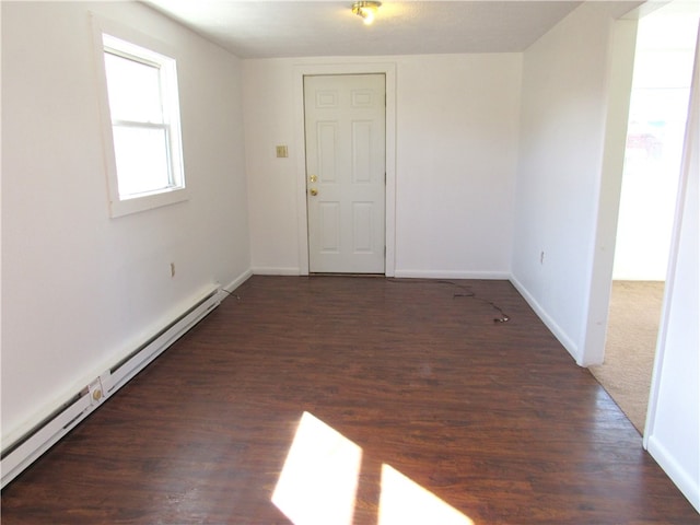 empty room with a baseboard radiator and dark hardwood / wood-style floors