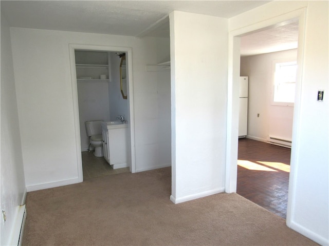 hall with carpet flooring, sink, and baseboard heating