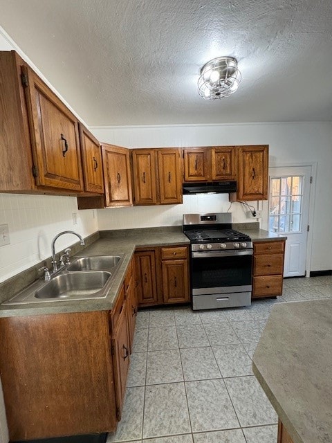 kitchen with gas stove, a textured ceiling, sink, and light tile patterned flooring