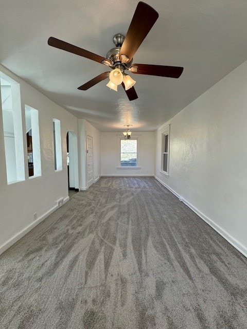 unfurnished living room with carpet floors and ceiling fan with notable chandelier