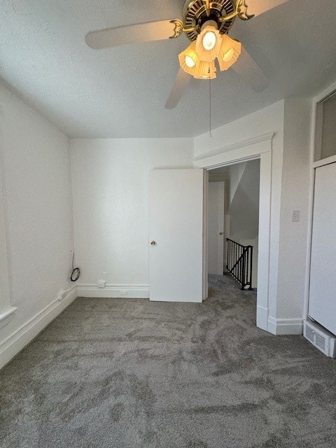 unfurnished room with a textured ceiling, carpet flooring, and ceiling fan