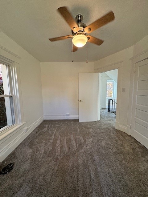 carpeted spare room with ceiling fan