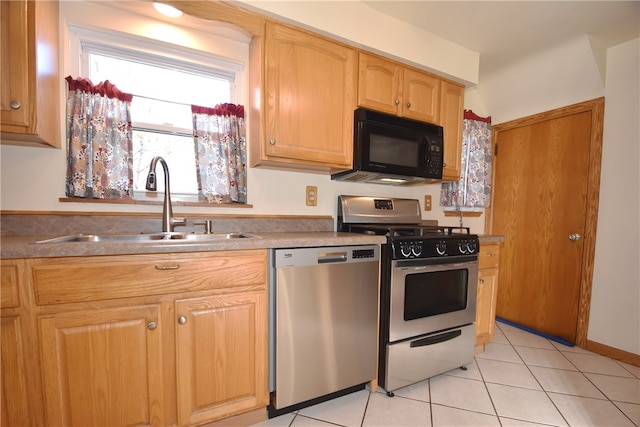 kitchen with stainless steel appliances, light tile patterned floors, and sink