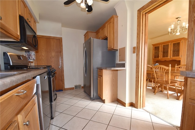 kitchen with pendant lighting, ceiling fan with notable chandelier, light tile patterned floors, and stainless steel appliances