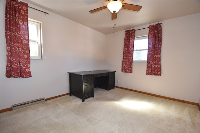 spare room with light colored carpet, ceiling fan, and a baseboard heating unit