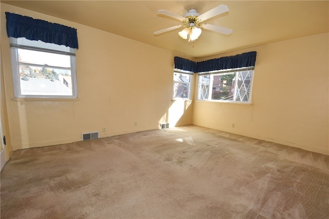 carpeted spare room featuring ceiling fan