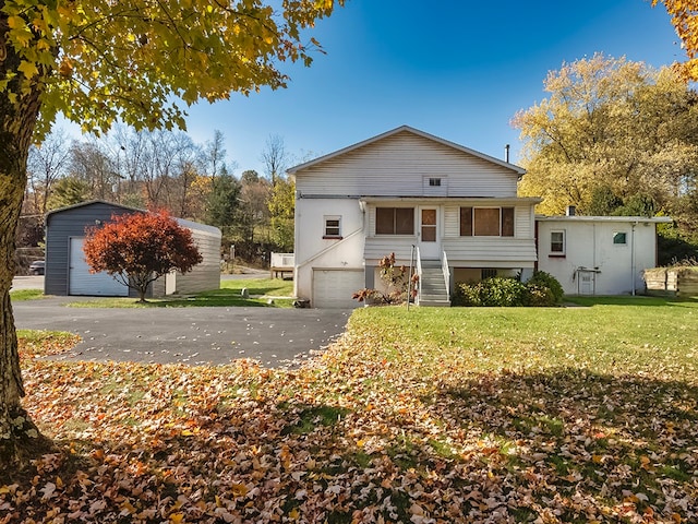 back of house featuring a yard and a garage