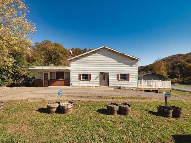 rear view of house featuring a patio area, a yard, and a deck with mountain view