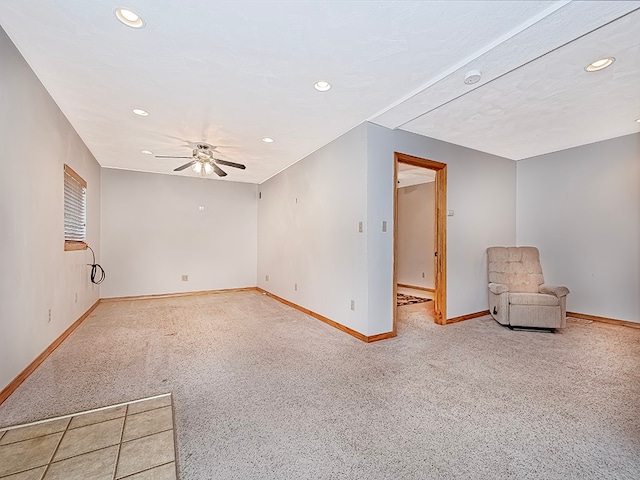 spare room featuring light colored carpet and ceiling fan