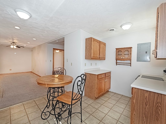 kitchen featuring range, a textured ceiling, light carpet, ceiling fan, and electric panel