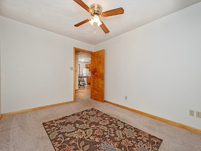 unfurnished room featuring ceiling fan and carpet flooring